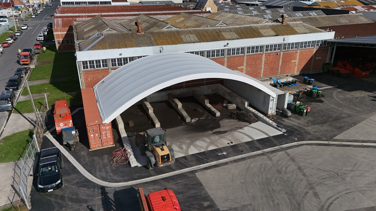 Wide-span truss container shelter at a harbour-side port site